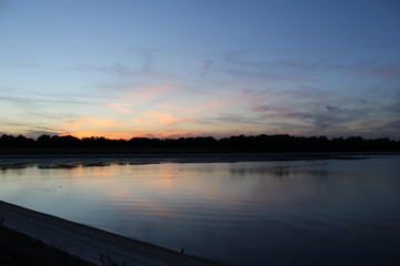Sunset over ducks swimming on depleted reservoir