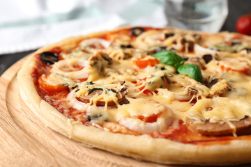 Tasty pizza on wooden board, closeup