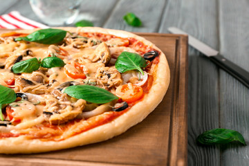 Board with tasty pizza on wooden table, closeup