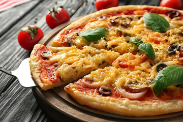 Tasty pizza and shovel with slice, closeup