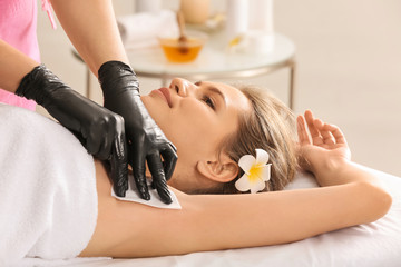 Woman having hair removal procedure with wax in salon