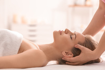 Obraz na płótnie Canvas Young woman having head massage in beauty salon