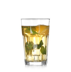 Glass of cold lemonade with mint leaves and lemon on white background
