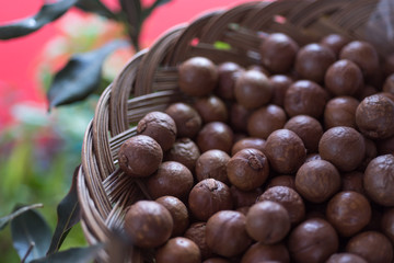 Macadamia nuts on scoop on Wicker basket, seletive focus