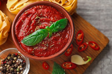 Bowl with spicy tomato sauce on table, closeup