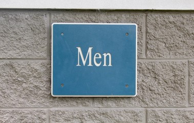 A men restroom sign on the brick wall and a close view.
