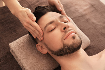 Fototapeta na wymiar Young man receiving massage at spa salon