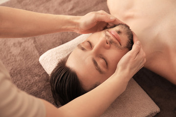 Obraz na płótnie Canvas Young man receiving massage at spa salon