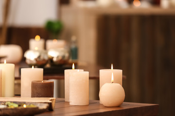 Burning candles on table in spa salon