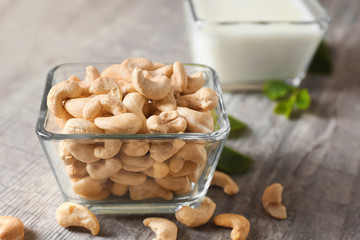 Glass bowl with tasty cashew nuts on table