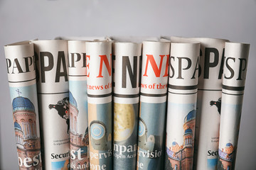 Rolled newspapers on grey background