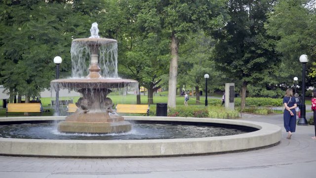 People walking past the Confederation Park Fountain in Canada's Capital City, Ottawa, Ontario.