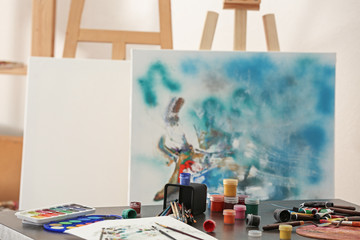 Paints and tools of professional artist on table