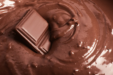 Tasty melted chocolate with piece, closeup