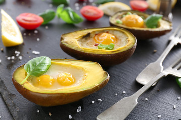 Avocado baked with eggs on table