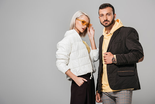  couple of models in autumn jackets posing isolated on grey background