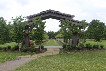 Obraz premium The wooden arch in the parks garden on a cloudy day.