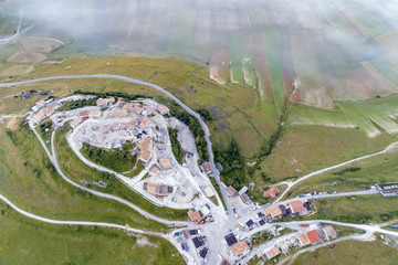 Flying on Castelluccio di Norcia, between ruins and bloom of flowers 
