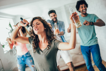 Group of friends playing karaoke at home. Concept about friendship, home entertainment and people