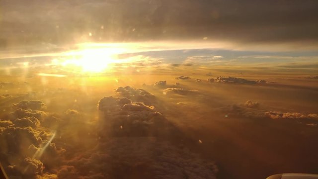 Ungraded clip of a beautiful golden hour sunset view from plane window