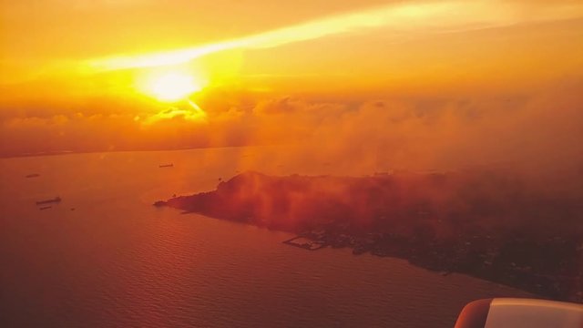 Ungraded clip of a beautiful golden hour sunset view from plane window