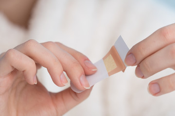 Woman using adhesive tape on hand.