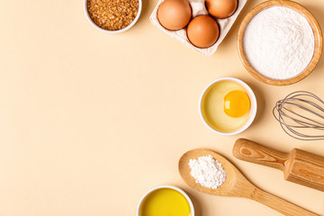 Ingredients and utensils for baking on a pastel background.