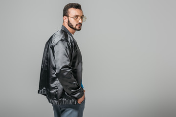 Fototapeta premium confident handsome man in stylish black bomber isolated on grey background