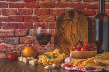 Products for cooking - pasta, tomatoes, garlic, olive oil and red wine.