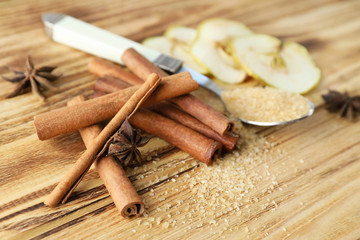 Fototapeta na wymiar Cinnamon sticks and sugar on wooden background