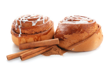 Tasty sweet buns with cinnamon sticks and powder on white background