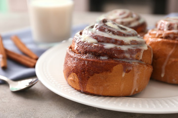 Plate with tasty cinnamon buns on table, closeup