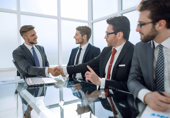 handshake financial partners over the negotiating table.