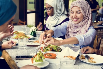 Islamic women friends dining together with happiness - obrazy, fototapety, plakaty