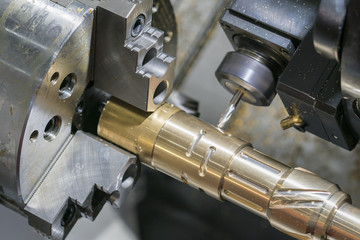 Operator machining automotive part by cnc turning machine,