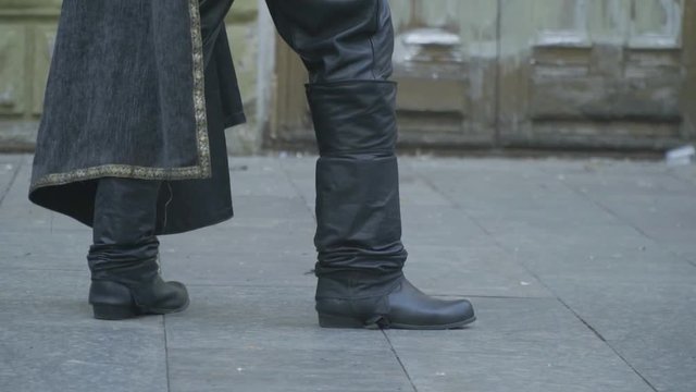 Legs of a man in leather boots