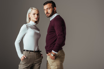 couple posing in fashionable autumn outfit, isolated on grey