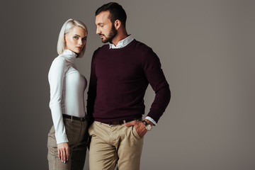 stylish couple posing in elegant autumn outfit, isolated on grey