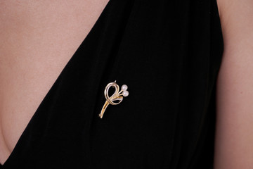 Woman wearing a golden brooch with a flower