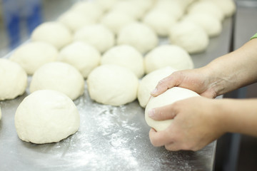 Fototapeta na wymiar the cook kneads pieces of dough
