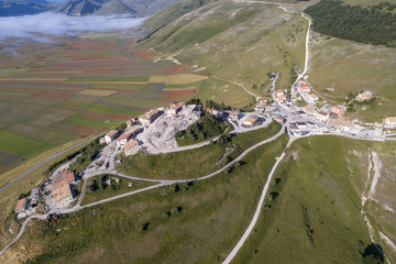Flying on Castelluccio di Norcia, between ruins and bloom of flowers
