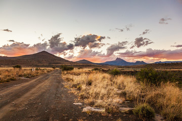 Fototapeta na wymiar The sun sets behind the mountains in the Karoo near Nieu Bethesda, South Africa.