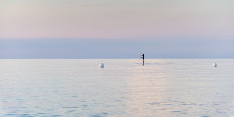 Naklejka premium single man on Stand Up Paddle Board. SUP. in beatutiful sunset
