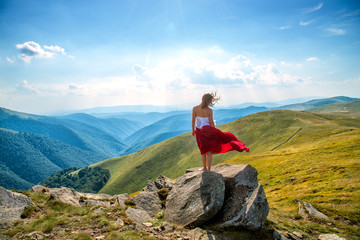 Naklejka premium Young woman on the top of mountain
