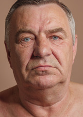 Aged man portrait on light background.