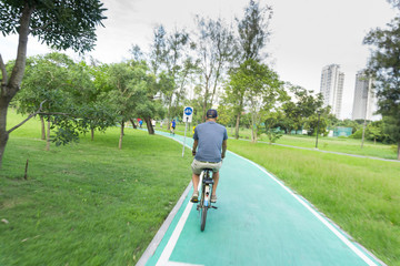 Man ride a bicycle at public park.