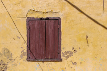 Window of an old house with a closed shutter