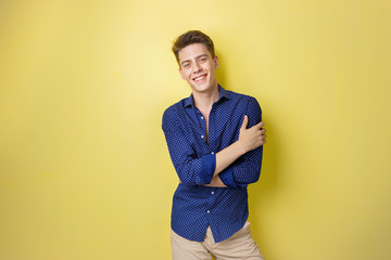Obraz premium Friendly looking cheerful european guy wearing blue shirt smiling standing over yellow background