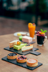 served tableful with little cakes, pie and beverages at kids birthday