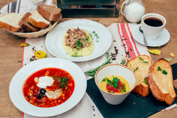 full dinner for one person with few dishes at wooden background